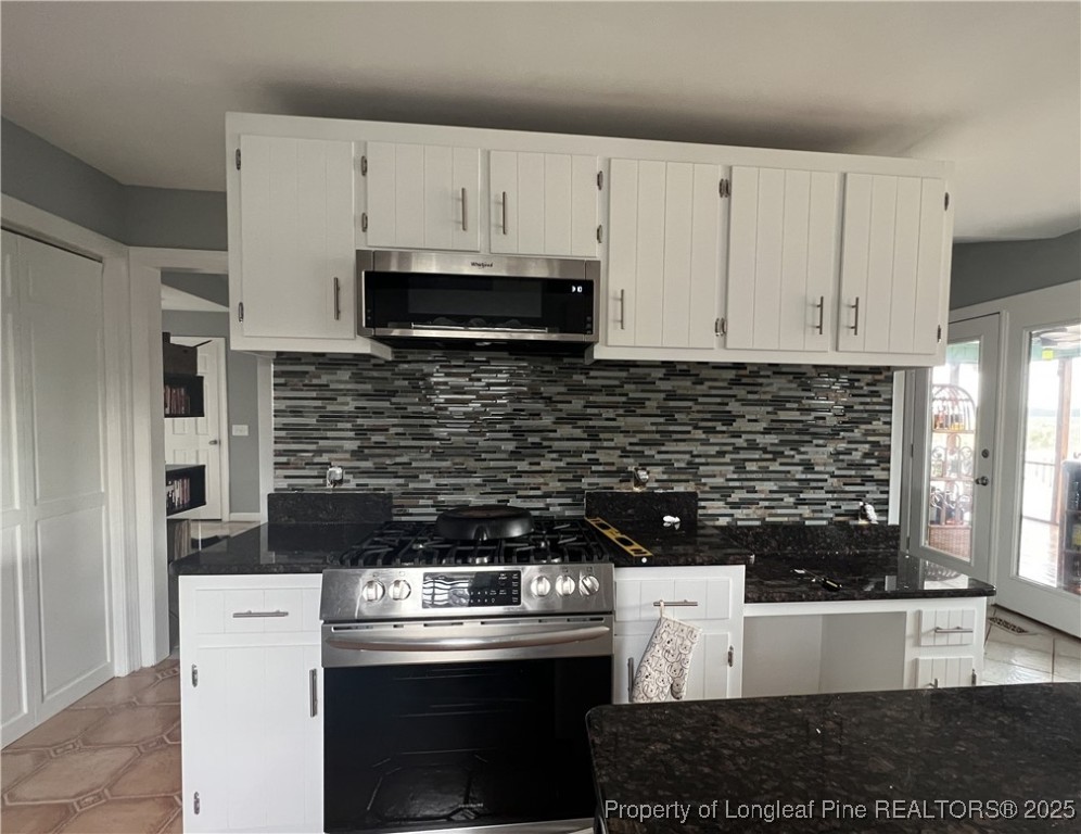 692 Cedar Point Vass, NC 28394 - Photo 13 of 46 a kitchen with white cabinets and black appliances