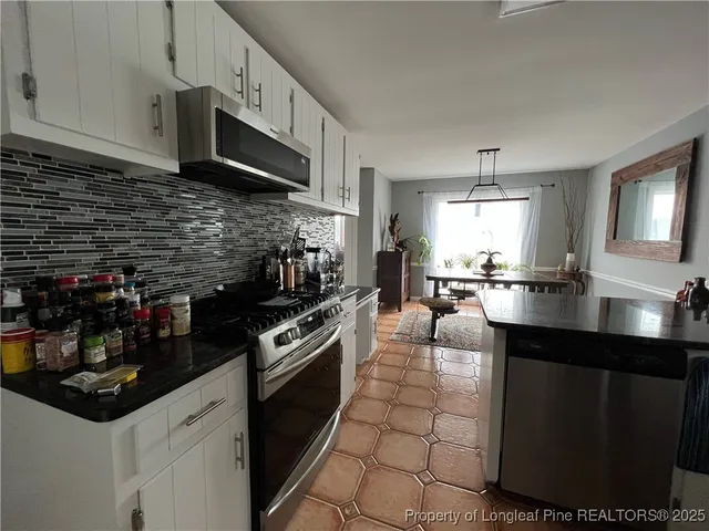 a kitchen with stainless steel appliances a sink a stove and cabinets