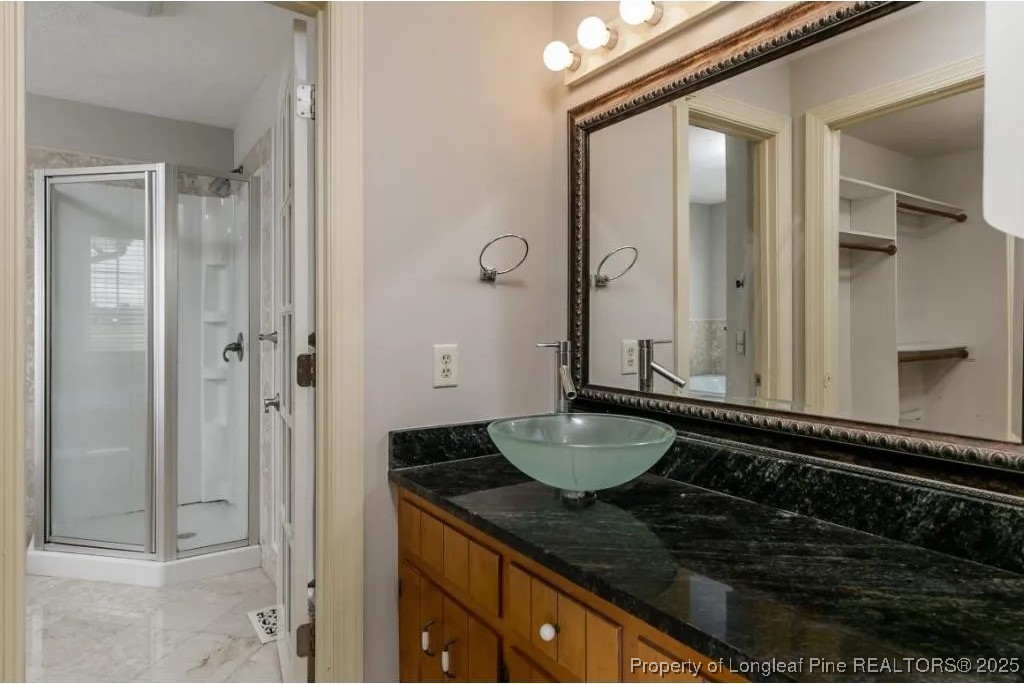 692 Cedar Point Vass, NC 28394 - Photo 20 of 46 a bathroom with a granite countertop sink a mirror and shower