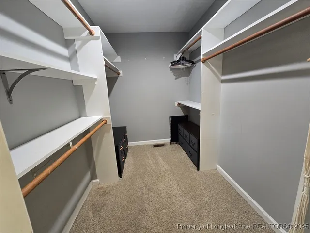 a view of walk in closet with clothes and shoes