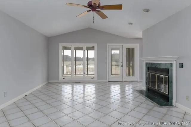 a view of an empty room with a fireplace and a window