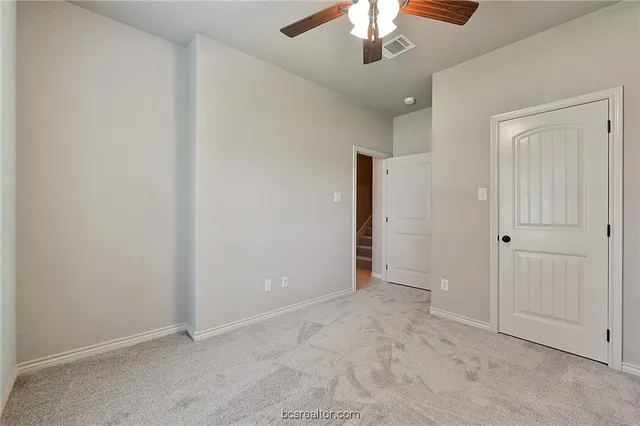 an empty room with a chandelier fan