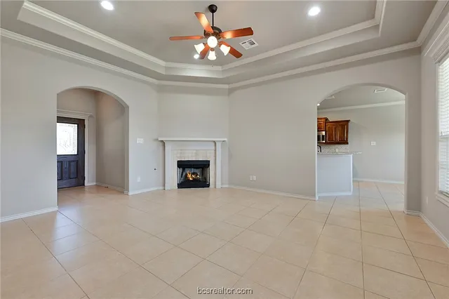 an empty room with fan and fireplace
