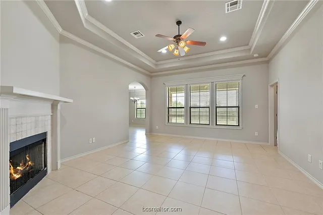 a view of an empty room with a fireplace and a window