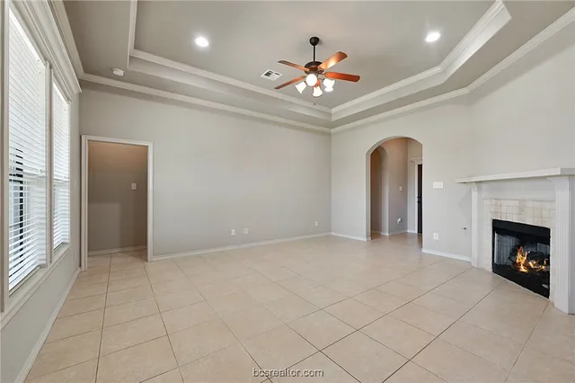 an empty room with fireplace and fan