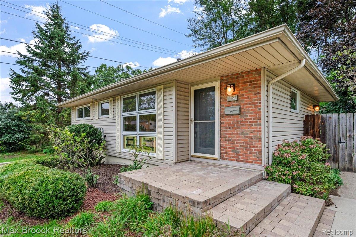 1330 Oak Street Rochester, MI 48307 - Photo 1 of 35 Brick facade with horizontal siding, paver stone entry, front door with screen, and exterior wall sconces