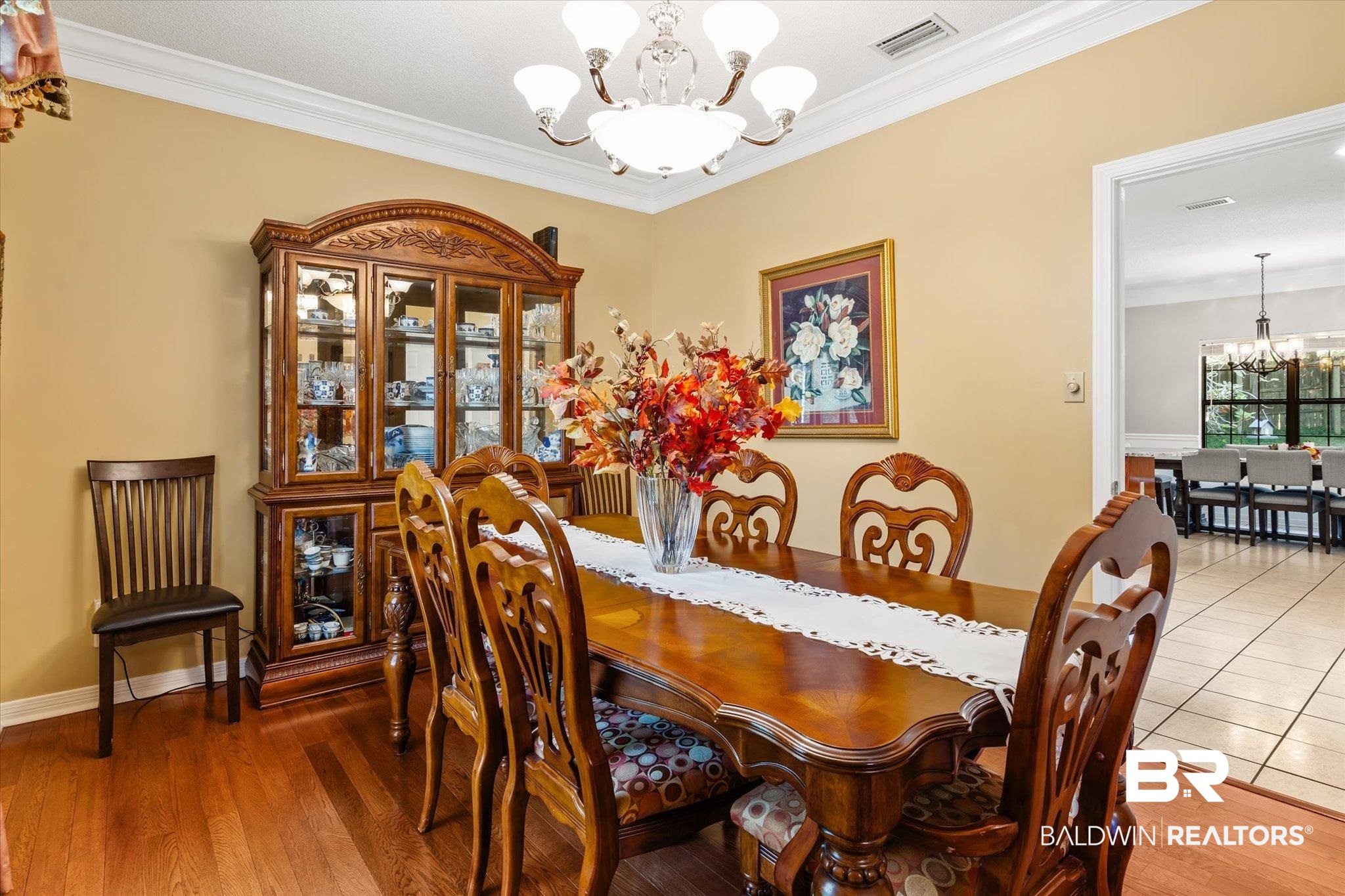 7360 Bridgewood Court Mobile, AL 36695 - Photo 6 of 30 Dining area featuring a notable chandelier, crown molding, and wood-type flooring