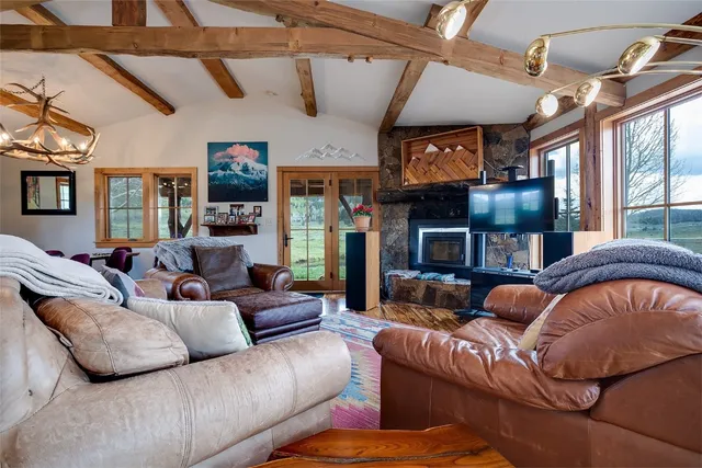 a living room with furniture a fireplace and a ceiling fan