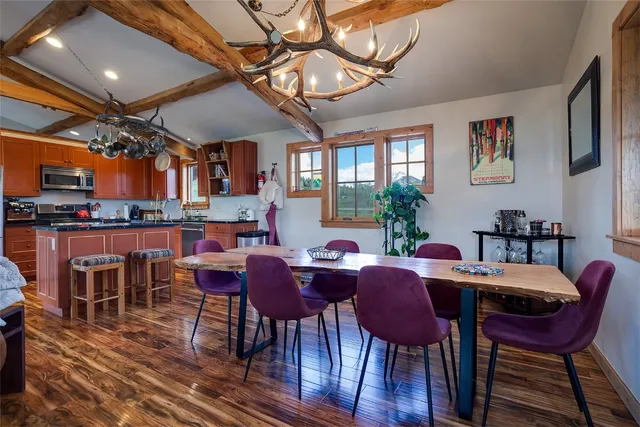 a view of a dining room with furniture a chandelier and wooden floor