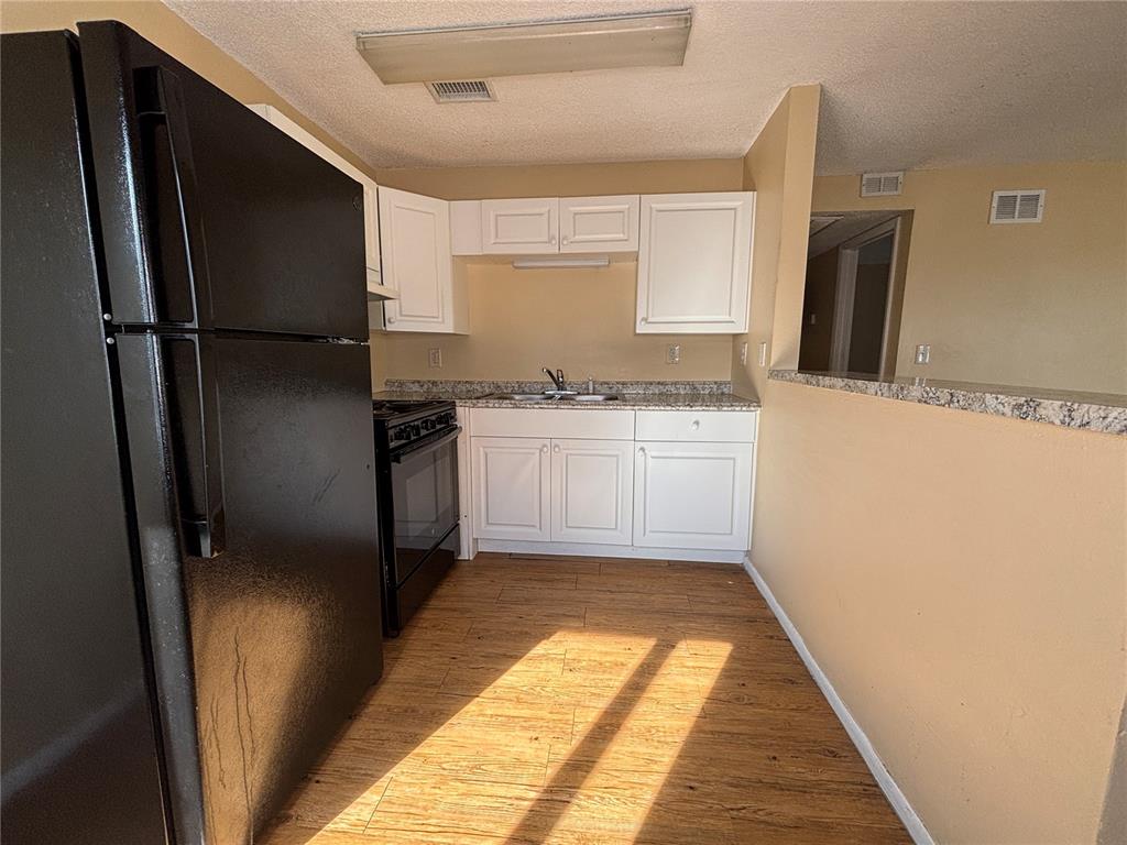 800 North Fiske Boulevard, Unit 815 Cocoa, FL 32922 - Photo 7 of 14 a kitchen with granite countertop stainless steel appliances a refrigerator counter top space and cabinets