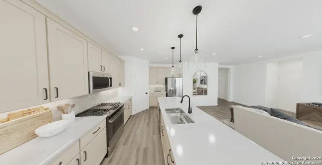 a kitchen with stainless steel appliances kitchen island granite countertop a sink and white cabinets