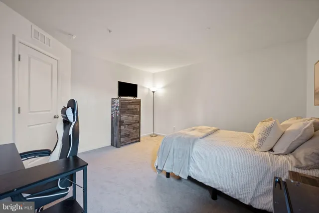 a bedroom with a bed and a view of living room