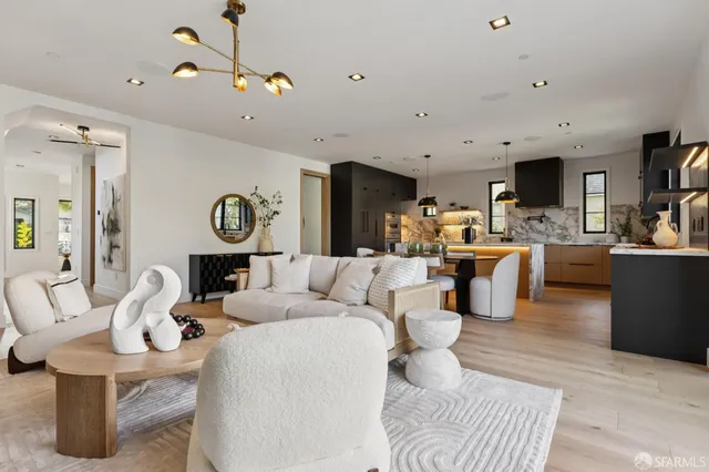 a living room with furniture kitchen view and a large window