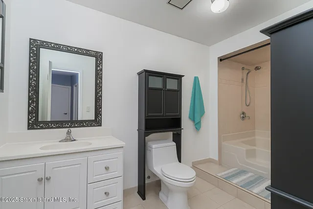 a bathroom with a toilet a sink and mirror