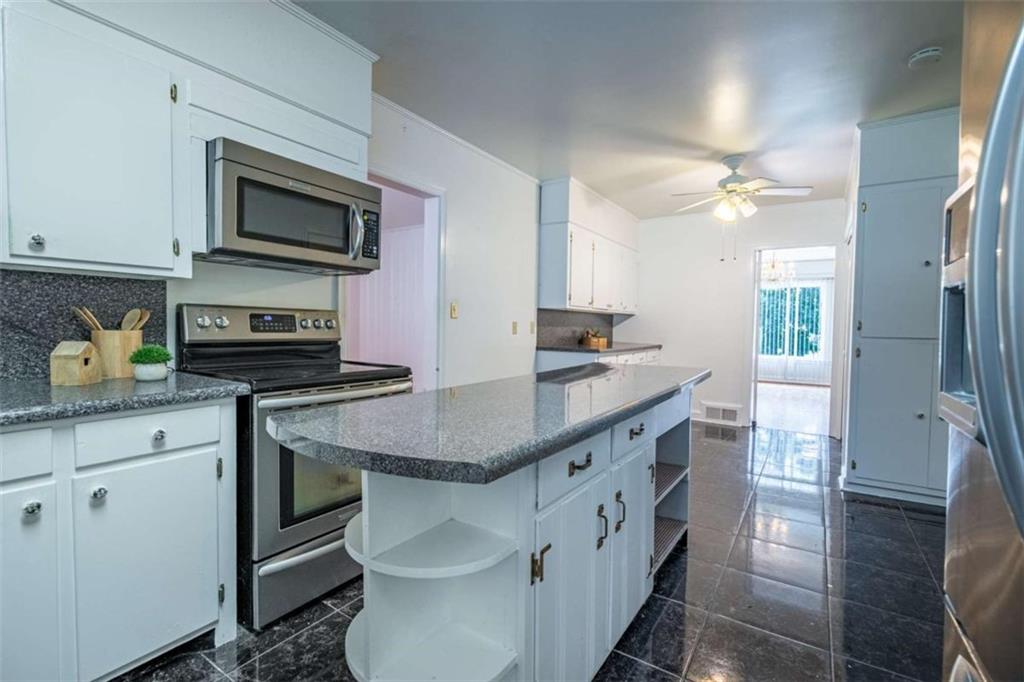 112 College Circle Cedartown, GA 30125 - Photo 14 of 35 a kitchen with stainless steel appliances granite countertop a sink a stove microwave and cabinets