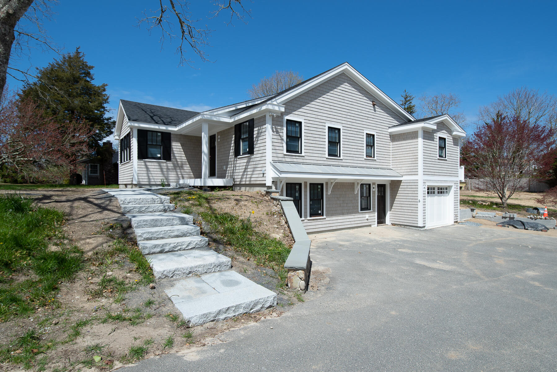 86 West Road Orleans, MA 02653 - Photo 4 of 16 a view of a white house with a yard plants and large tree