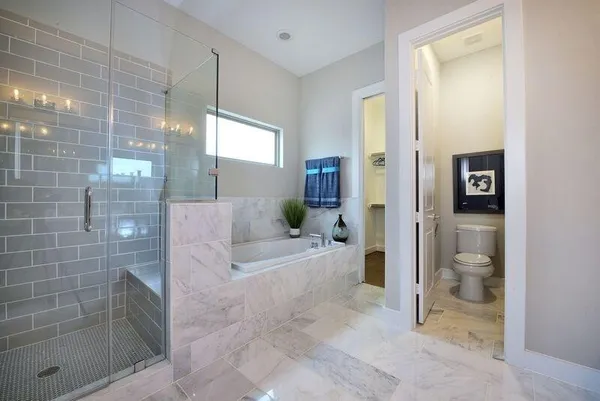 a bathroom with a bathtub and a glass door shower
