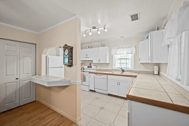 a kitchen with granite countertop white cabinets and white appliances