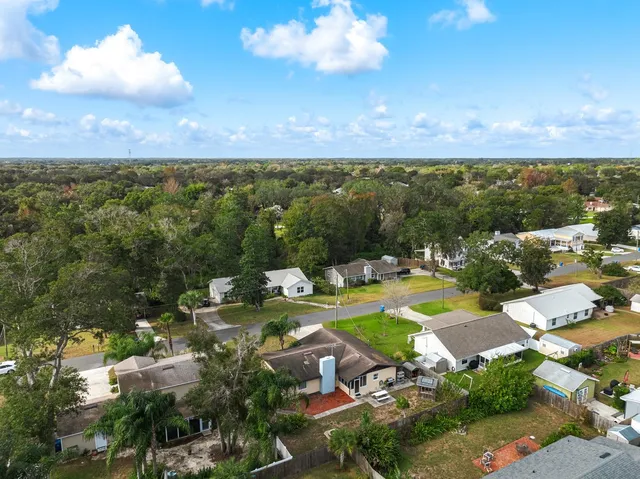 an aerial view of residential houses with outdoor space and swimming pool