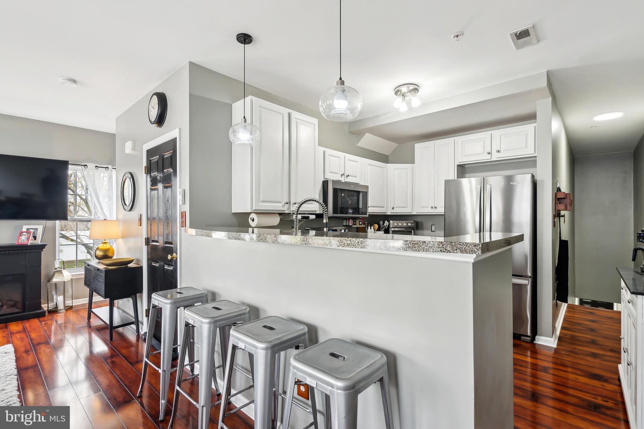 28 Teal Court Riverside, NJ 08075 - Photo 6 of 24 a kitchen with stainless steel appliances kitchen island granite countertop a refrigerator a stove top oven a sink dishwasher and white cabinets with wooden floor