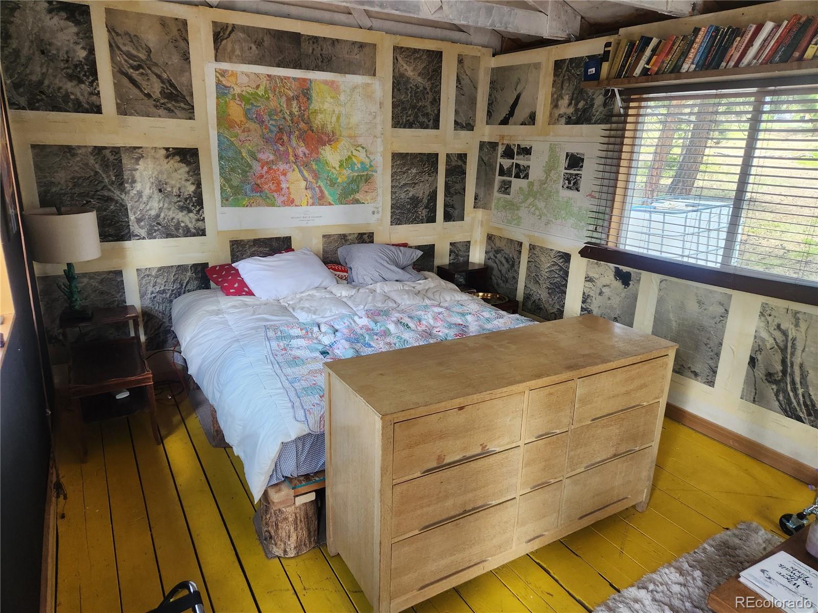3447 Pathfinder Road Florissant, CO 80816 - Photo 29 of 40 a bed sitting in a bedroom next to a window