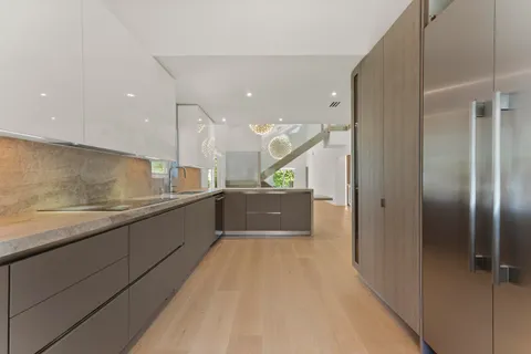 a large kitchen with stainless steel appliances kitchen island a large counter top and a refrigerator