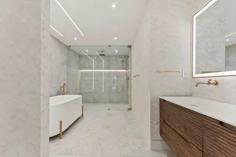 a bathroom with a sink a toilet and shower