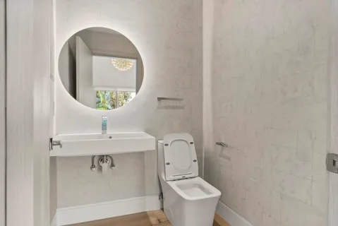 a bathroom with a toilet sink and mirror