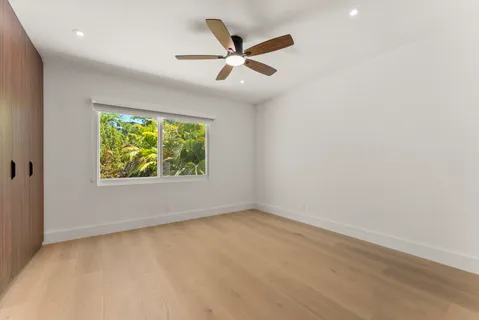 an empty room with window and ceiling fan