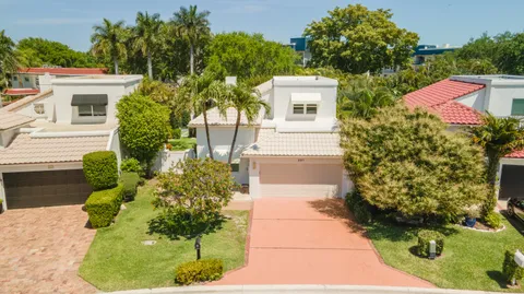 a front view of a house with a yard and potted plants