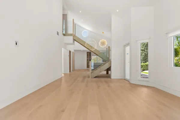 an empty room with windows and wooden floor