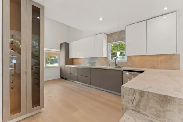 a kitchen with stainless steel appliances kitchen island granite countertop a refrigerator and a sink