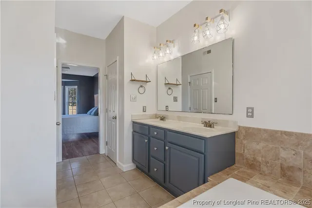 a bathroom with a granite countertop sink a large mirror and a bathtub