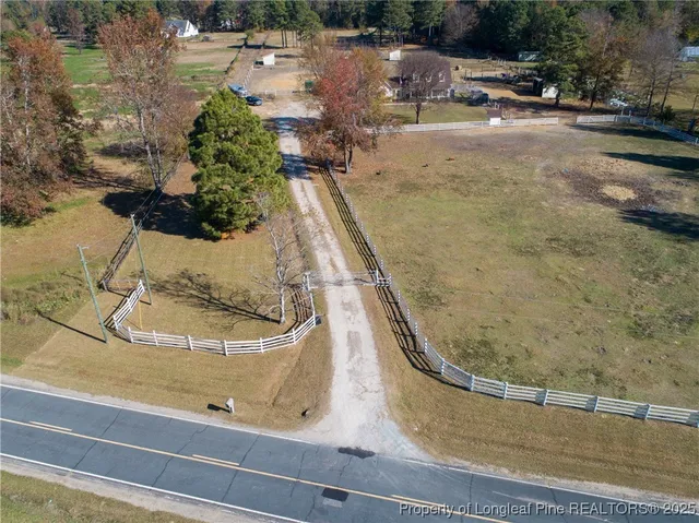 an aerial view of residential houses with outdoor space and trees