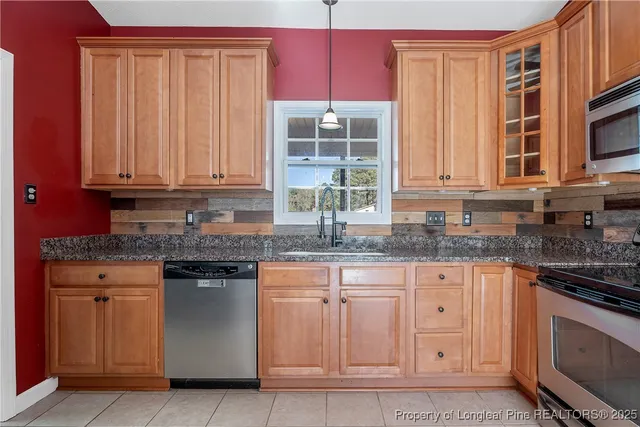 a kitchen with granite countertop a sink stainless steel appliances and cabinets