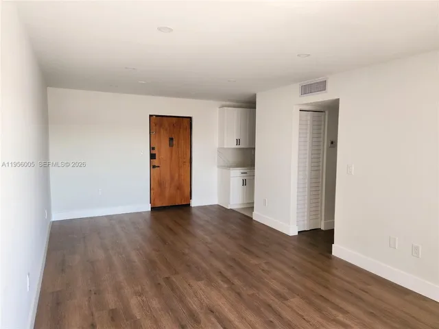 an empty room with wooden floor and closet