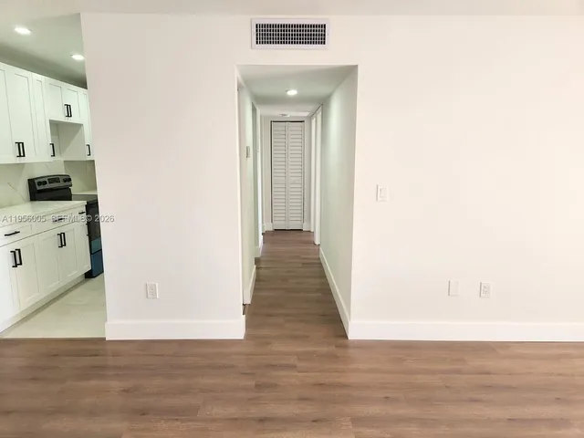 a view of a hallway with wooden floor