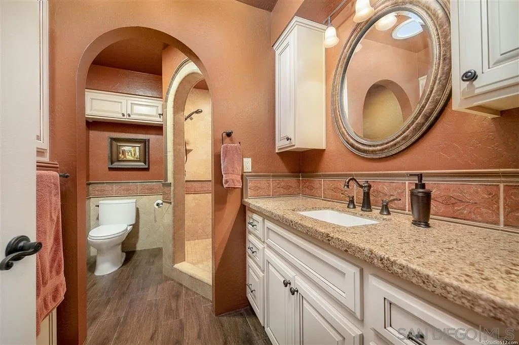 15738 Vesper Road Valley Center, CA 92082 - Photo 16 of 25 a bathroom with a granite countertop toilet a sink and a mirror