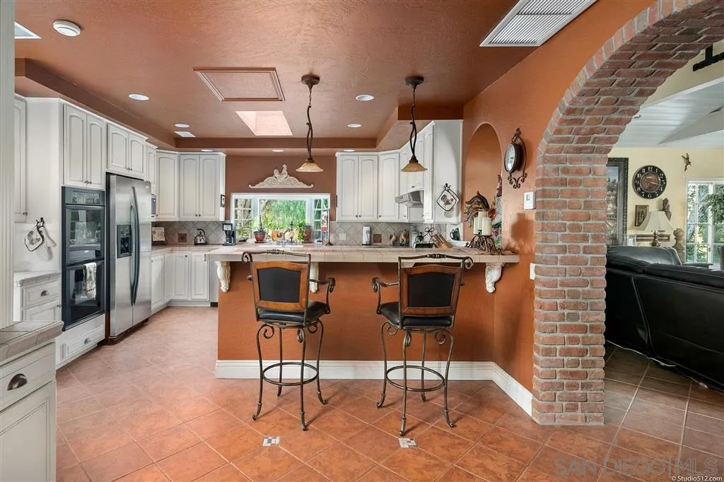15738 Vesper Road Valley Center, CA 92082 - Photo 9 of 25 a kitchen with stainless steel appliances kitchen island granite countertop a refrigerator and a stove top oven