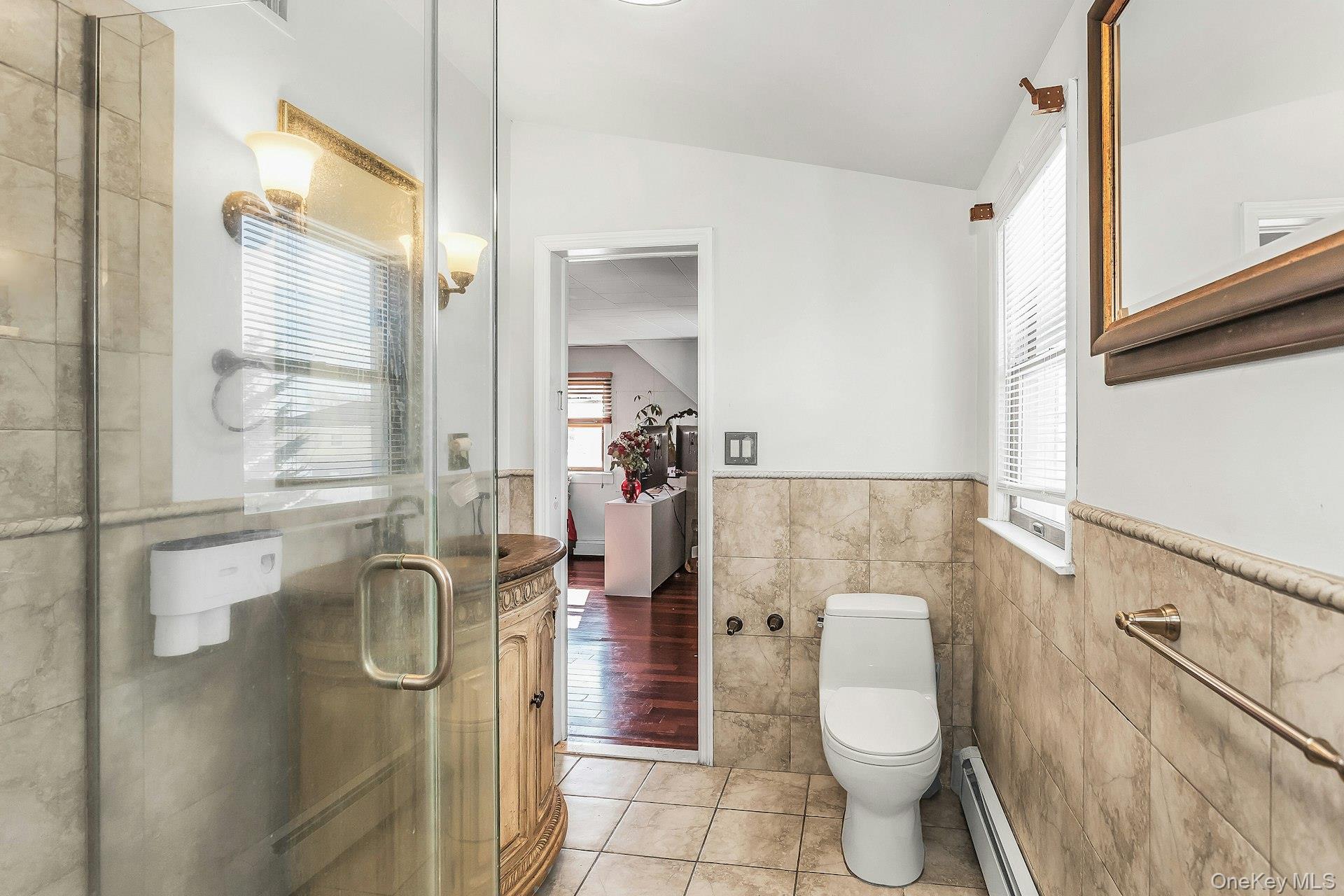 3348 3rd Street Oceanside, NY 11572 - Photo 19 of 32 a bathroom with a toilet a sink and shower