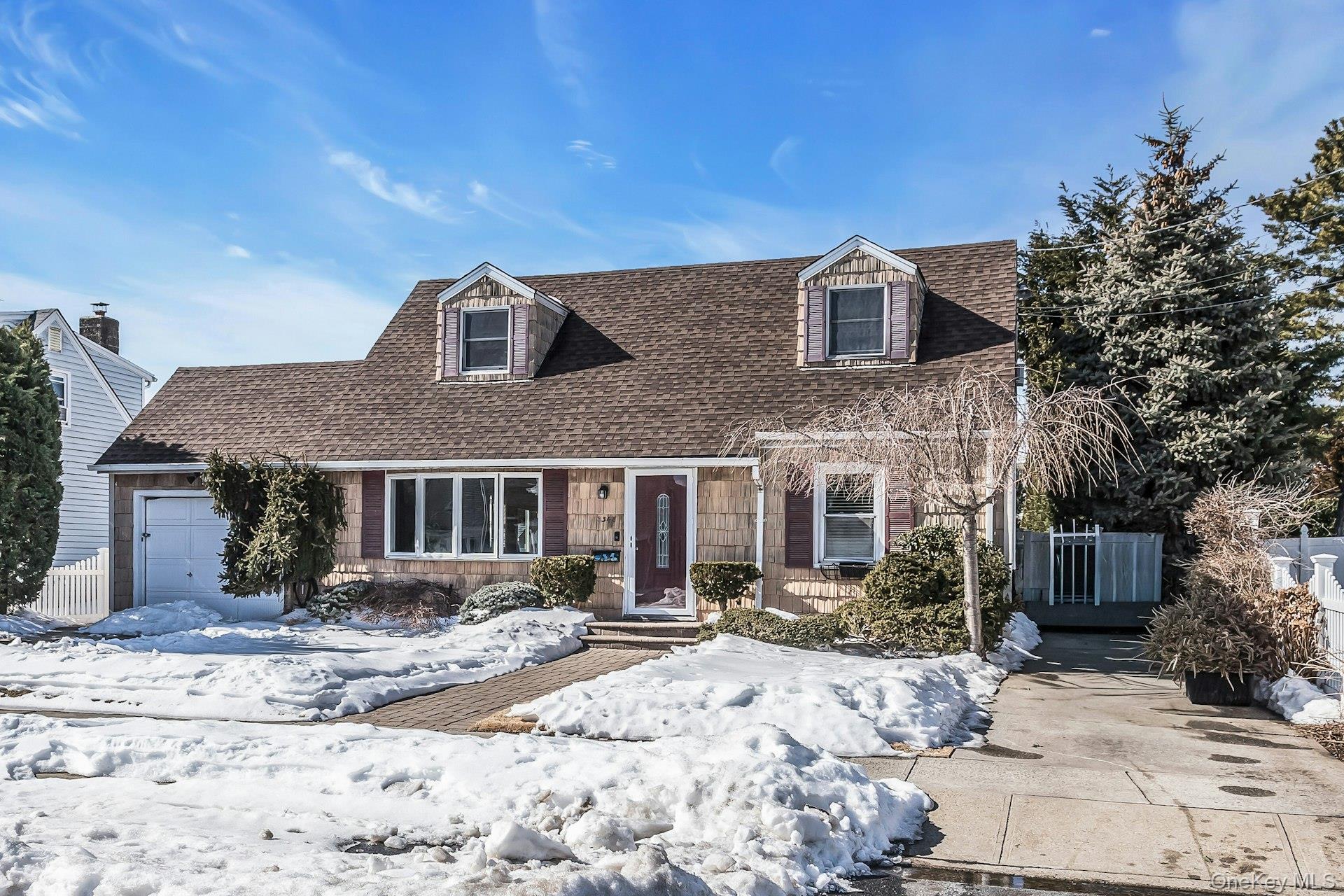 3348 3rd Street Oceanside, NY 11572 - Photo 3 of 32 a front view of a house with a yard