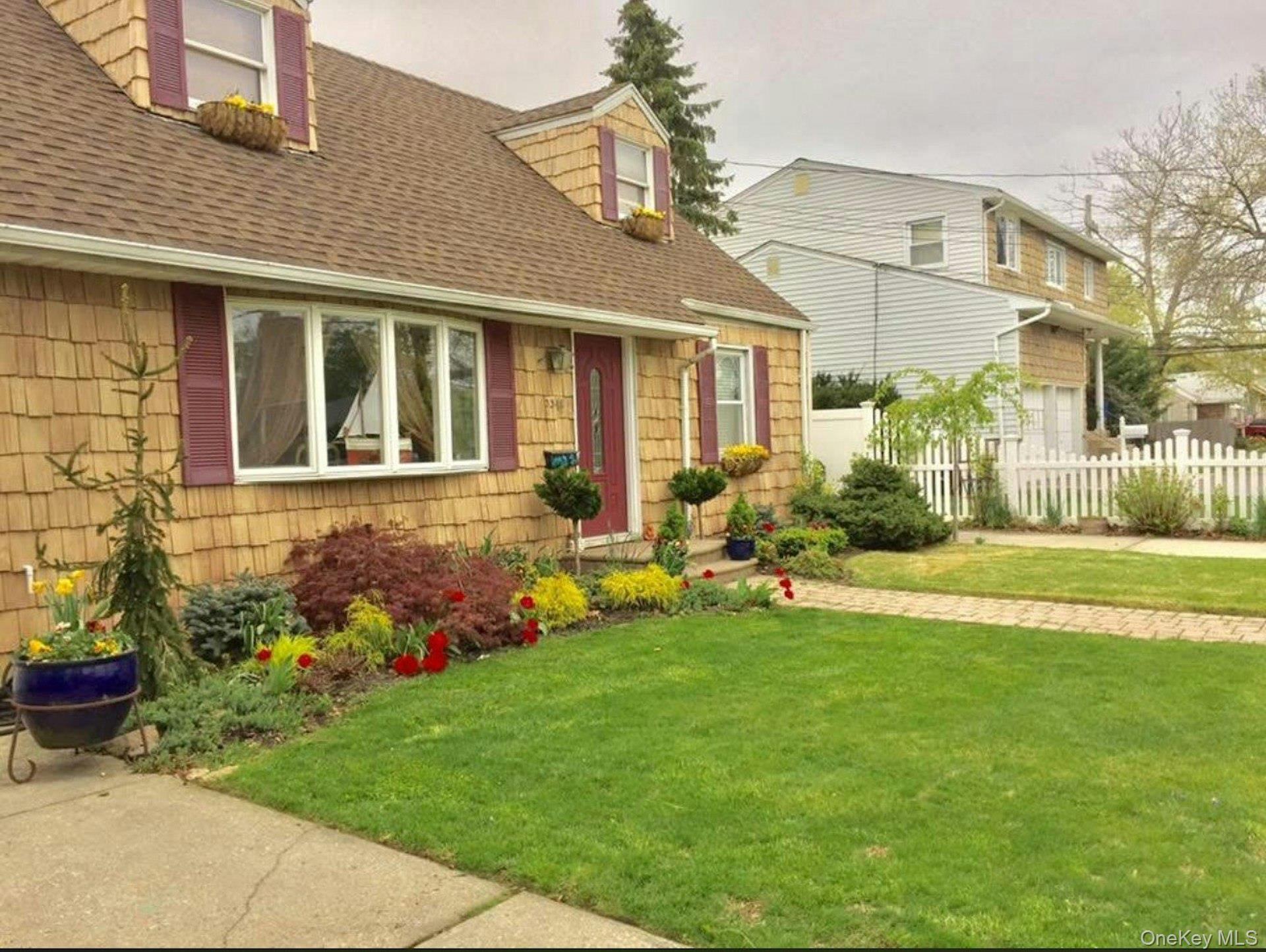 3348 3rd Street Oceanside, NY 11572 - Photo 31 of 32 a front view of a house with a garden and plants