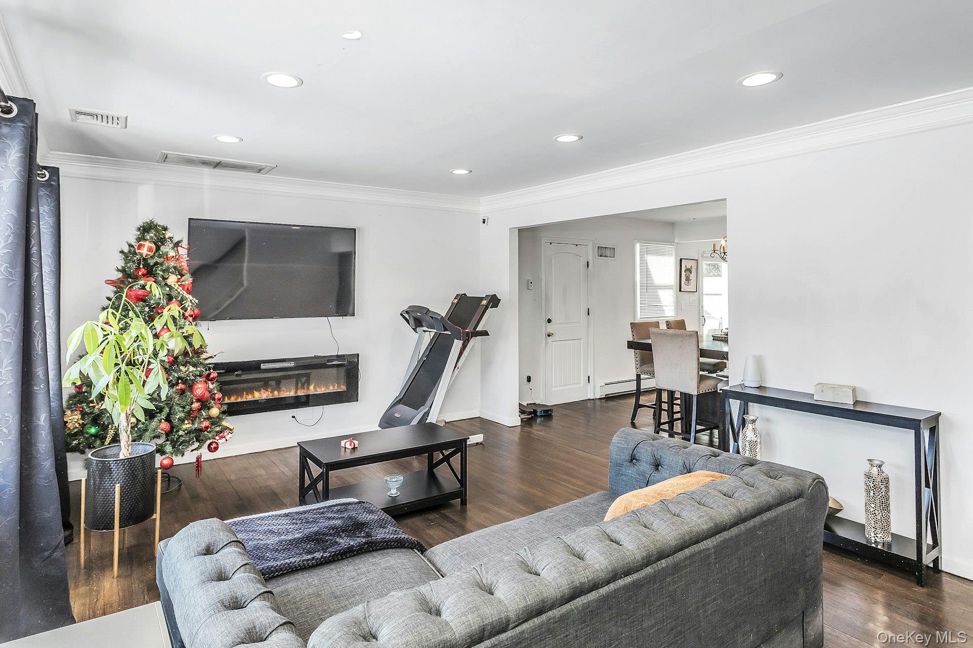 3348 3rd Street Oceanside, NY 11572 - Photo 4 of 32 a living room with furniture gym equipment and a flat screen tv