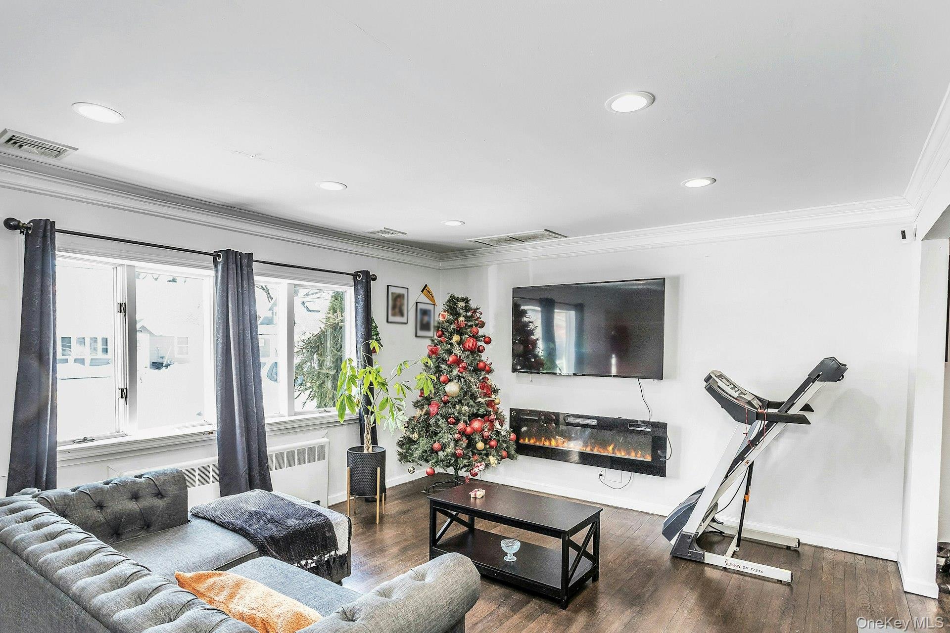 3348 3rd Street Oceanside, NY 11572 - Photo 5 of 32 a living room with furniture gym equipment and a flat screen tv