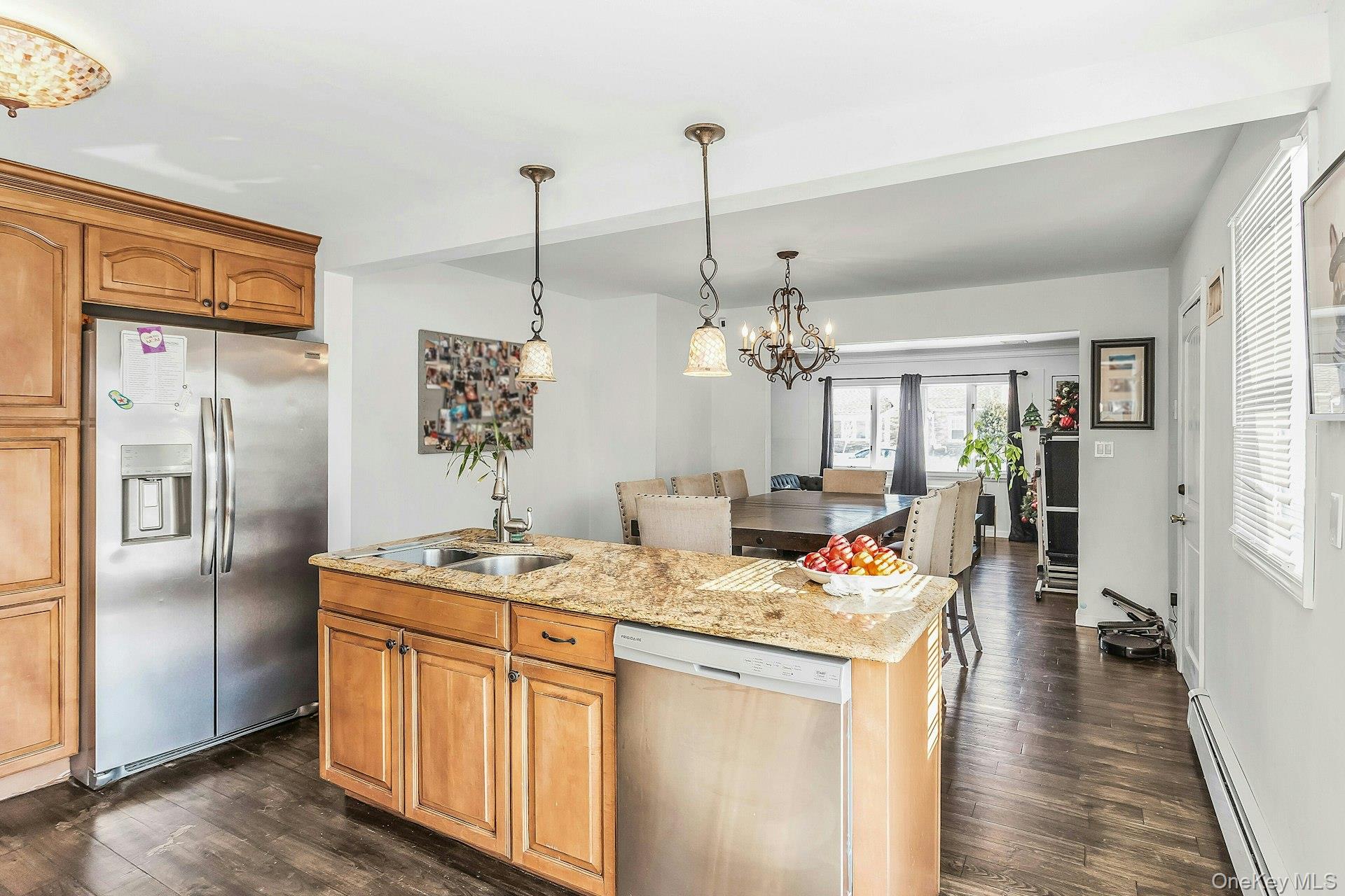 3348 3rd Street Oceanside, NY 11572 - Photo 10 of 32 a open kitchen with stainless steel appliances granite countertop a refrigerator a oven a sink dishwasher and a dining table with wooden floor