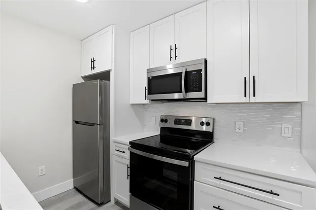 a kitchen with stainless steel appliances a refrigerator stove and microwave