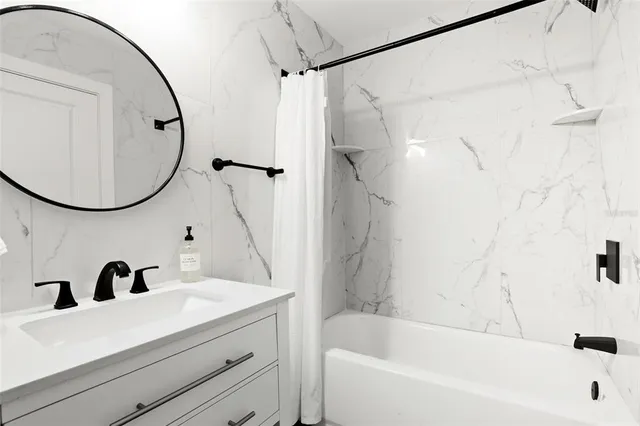 a bathroom with a tub a sink and a mirror