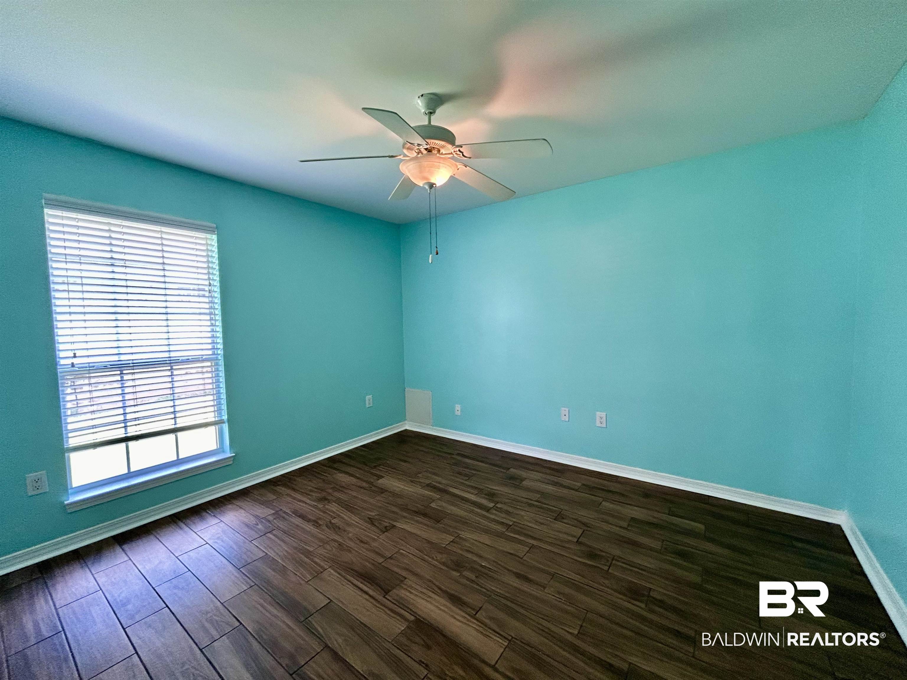 7198 Raintree Lane Gulf Shores, AL 36542 - Photo 23 of 33 Spacious room featuring wood-finish flooring, a window with horizontal blinds, and a ceiling fan with integrated lighting