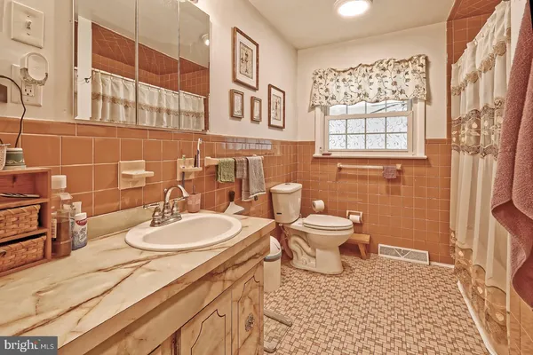 a bathroom with a sink a toilet and shower curtain