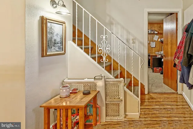 a view of staircase with lots of frames on wall and a window